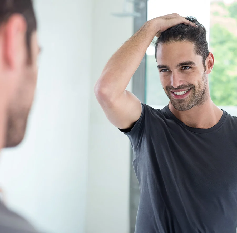 Man smiling staring at himself in the mirror