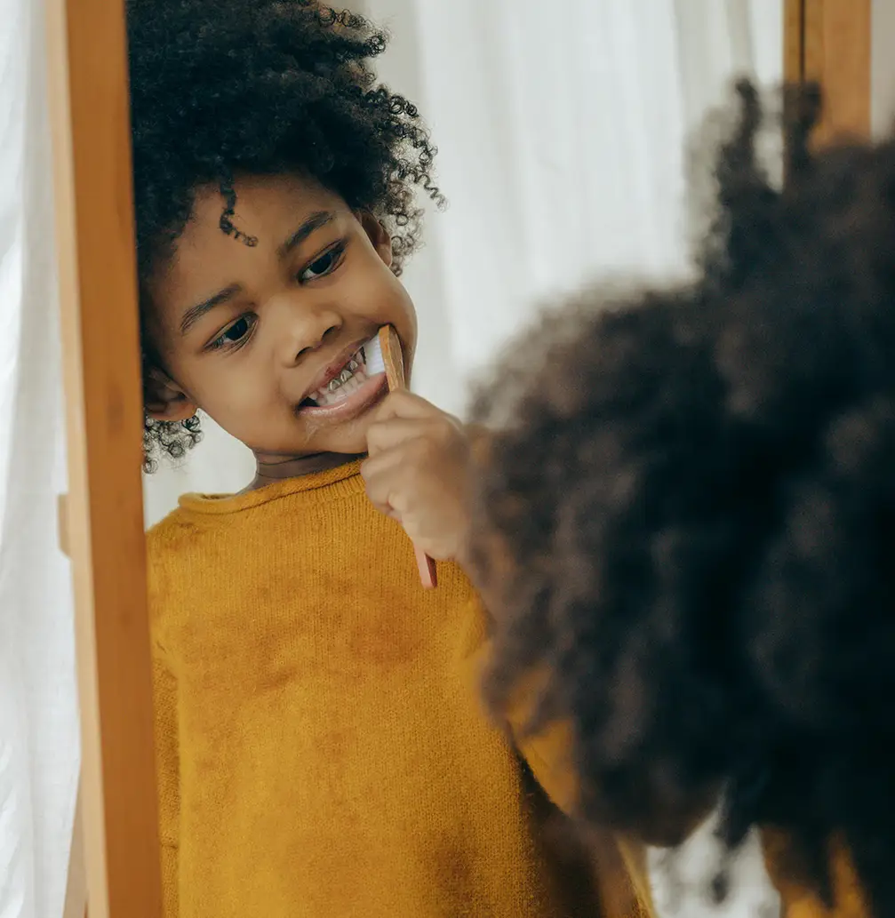 Child brushing teeth in the mirror